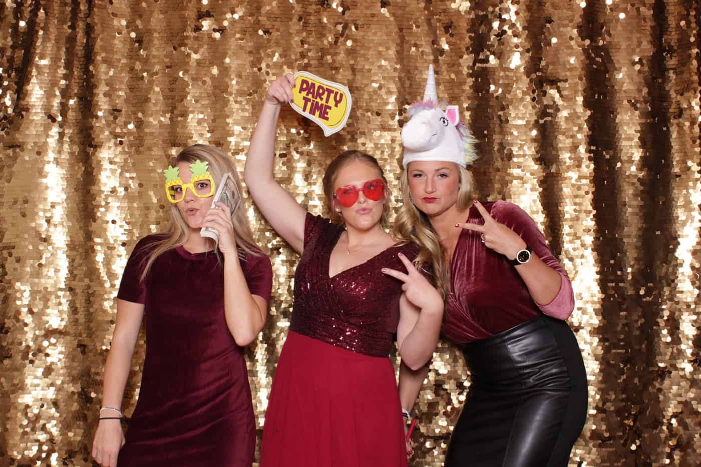 photo booth photo from a wedding reception with gold sequin backdrop