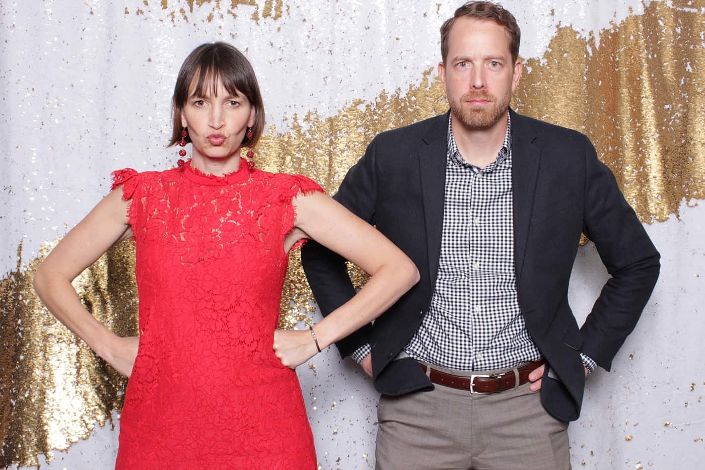 company christmas party photo booth photo taken against a white and gold sequin backdrop with christmas props