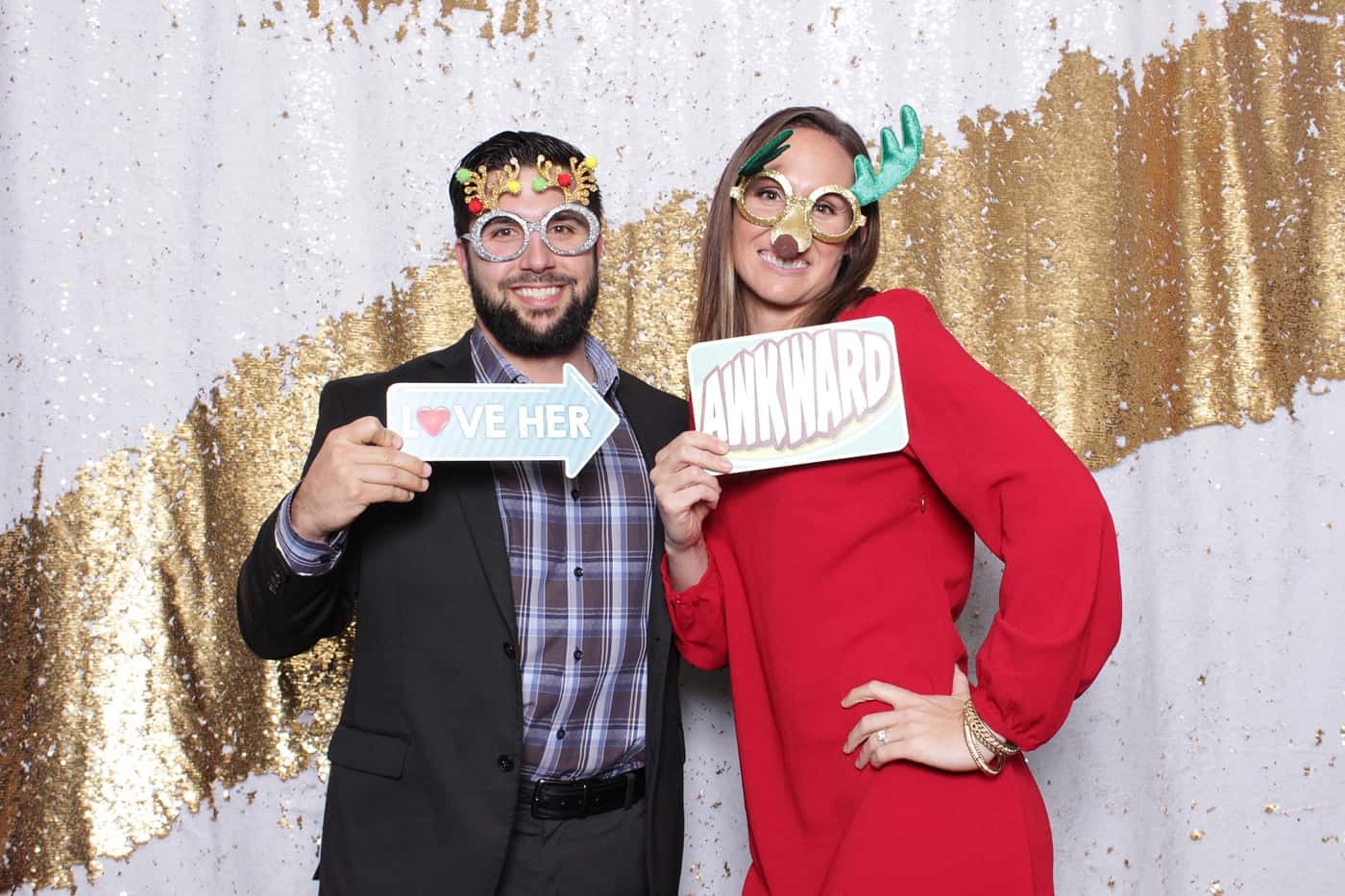 company christmas party photo booth photo taken against a white and gold sequin backdrop with christmas props
